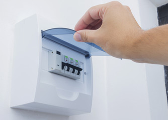 Electrician technician showing a residential electrical panel. Selective focus.