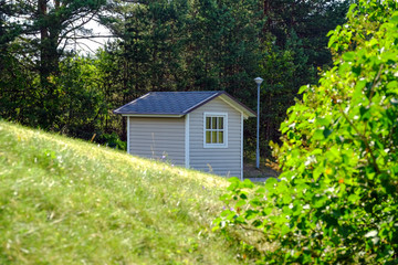Fototapeta na wymiar Rustic wooden blue old garden shed in resort area
