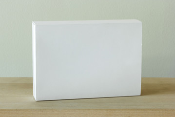blank white cardboard package box mockup on wooden table