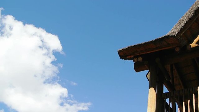 Thatch roof with clouds rolling in
