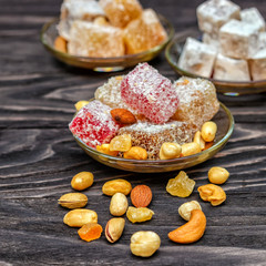 Traditional oriental sweets and traditional Turkish tea on a dark wooden background. Turkish desert-Rahat locum.