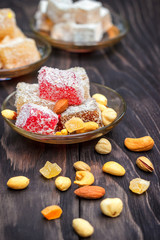 Traditional oriental sweets and traditional Turkish tea on a dark wooden background. Turkish desert-Rahat locum.