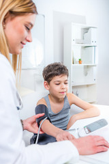 Pediatrician measuring boy’s blood pressure