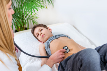 Pediatrician examining boy’s abdomen