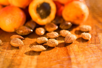 Fresh apricots and seeds on wooden surface
