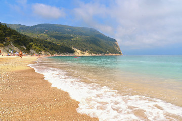paradise sand beach, blue cloudy sky, seascape and waves in Sirolo , Marche, Italy
