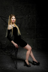 young girl in the studio; tall and beautiful girl with big eyes; 
model looks girl poses; 
model with long hair;
brown-haired European model; on a dark background near an iron chair