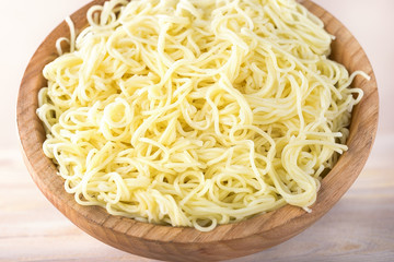 Egg noodles in wooden bowl.