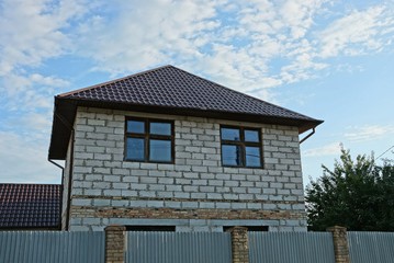 private gray brick house with windows behind the fence