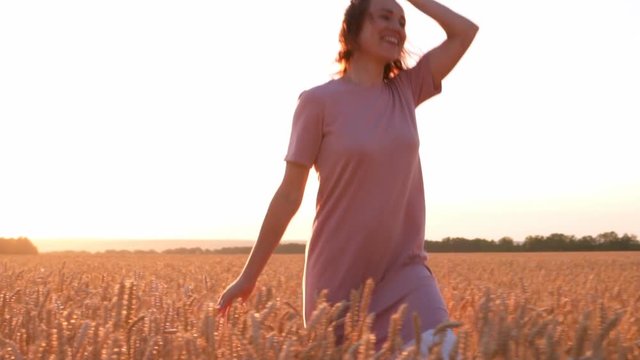 Joyful woman running and jumping in wheat field