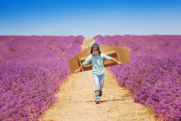 Boy aviator running through lavender field