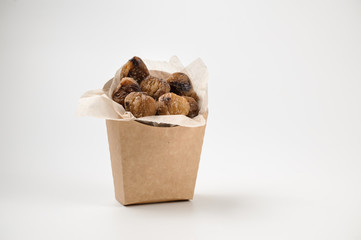 Tasty isolated chestnuts in paper bag on white background