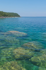 Bright clear aqua green water on Bruce Peninsula with big limestone rocks