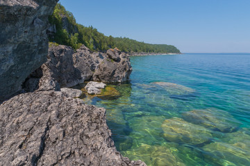 Bright clear aqua green water on Bruce Peninsula with big limestone rocks