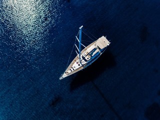 Aerial birds eye view from drone of yacht in deep blue sea - Powered by Adobe