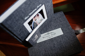 Elegant grey photo book or photo album and flash drive case on wooden stairs. - obrazy, fototapety, plakaty