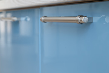Iron handle on kitchen furniture from varnished materials.