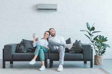 couple turning on air conditioner during the summer heat at home