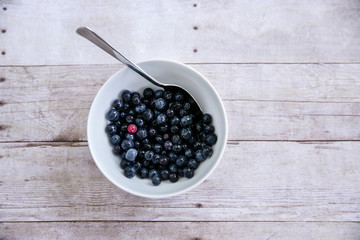 White Bowl with Blueberries and Spoon One Being Different Unique