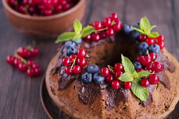 Homemade chocolate cake with chocolate icing, mint  and fresh berries.