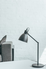 black lamp standing on table in room with grey sofa