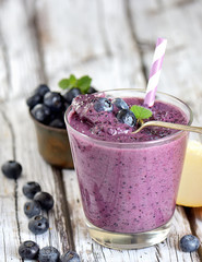 Blueberry smoothies juice a tasty healthy drink in a glass, drink the morning on white wooden background.