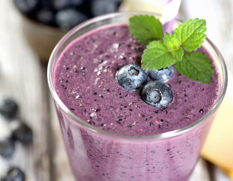 Blueberry smoothies juice a tasty healthy drink in a glass, drink the morning on white wooden background.