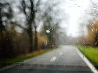 View through car windscreen during rainy winter day in lone atmospheric rural highway
