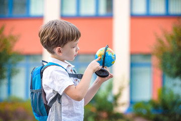 Portrait of a little boy holding a globe. Travel concept