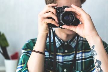 Hipster man focuses on an old camera