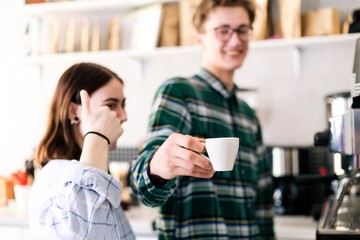 Young couple standing in a cafe with a Cup of coffee
