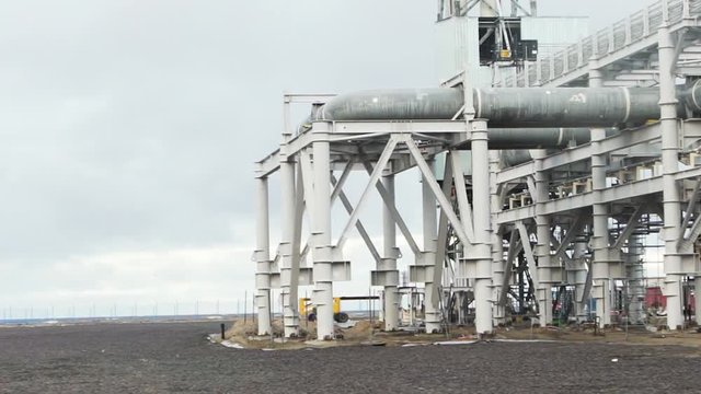 Thermal power plant,Energy power station. Infrastructure of a Hydroelectric Power Station with river in the background. Energetic. Video. Electricity factory with pipes and smoke.