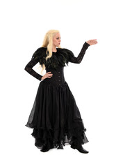 Fototapeta premium full length portrait of blonde girl wearing corset and long black gown. isolated on white studio background,