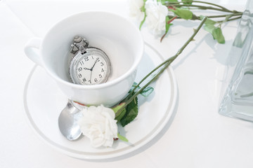 Vintage pocket watch. A closed up of a teacup with antique pocket watch inside. Tea break and tea time concept.