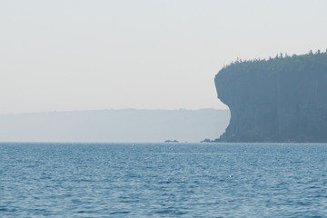Georgian bay coastline cliff silhouette (Cave point) in the early morning mist and fog background