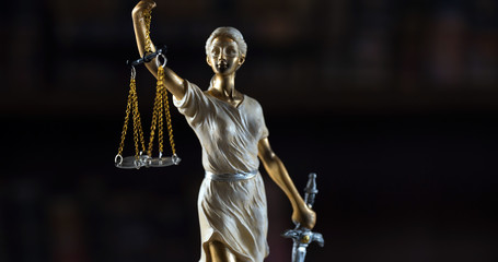 Obraz premium Justice Themis goddess sculpture on dark brown background.