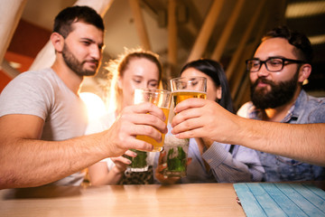 Friends at the bar clink with each other at the bar close-up