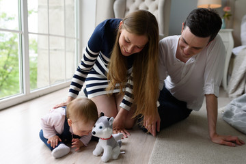 Happy parents playing with child at home