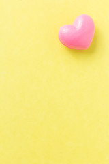 Red heart shape over yellow table. Valentines day symbol for background use. Love, romance, and passion.