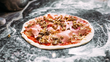 Delicious pizza prepared to be baked. Close-up.
