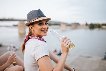 Gorgeous young woman drinking from a bottle. Looking at camera.