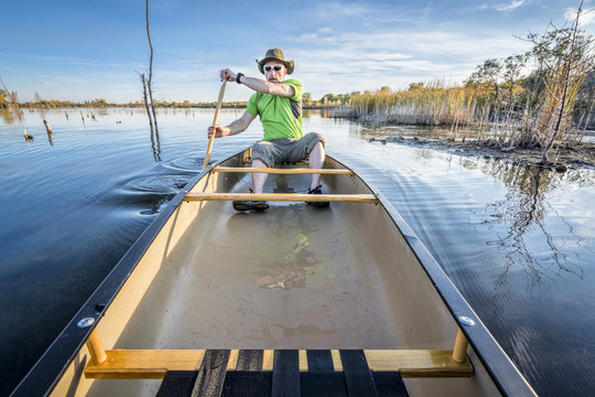 Paddling Canoe On Calm Lake