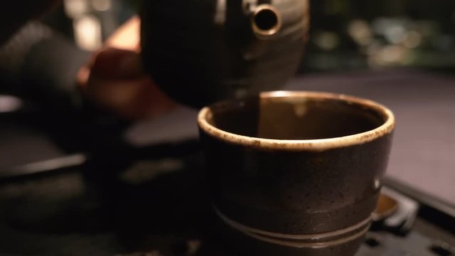 Japanese tradition. Pouring hot sake in the cup