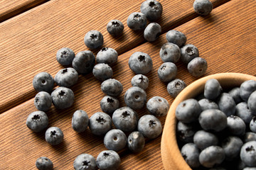Fresh blueberries on a wooden table in a wooden plate. Close up. The concept of natural food