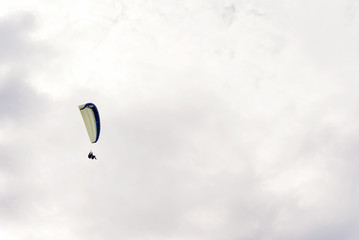 parachute skydiver flying in clouds, travel adventure concept, space for text