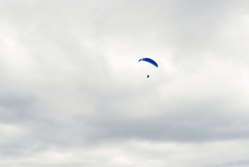 parachute skydiver flying in clouds, travel adventure concept, space for text