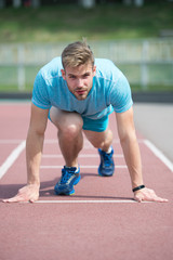 Start of sport career. Man runner on start position stadium background. Sportsman run outdoor at...