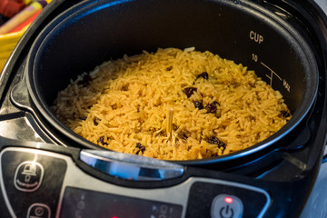 Close-up image of Pilaf with beef, carrots, onions, garlic, pepper and cumin in the modern multicooker. A traditional dish of Asian cuisine. Selective focus.