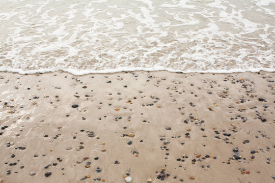 Fototapeta Top view of colorful stones on sand at the beach.