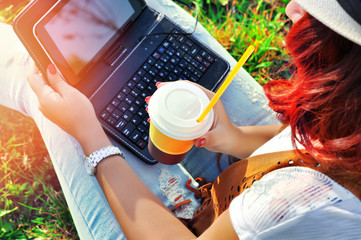 Relaxation with a cup of coffee and tablet. Beautiful young  hipster freelancer working on laptop...